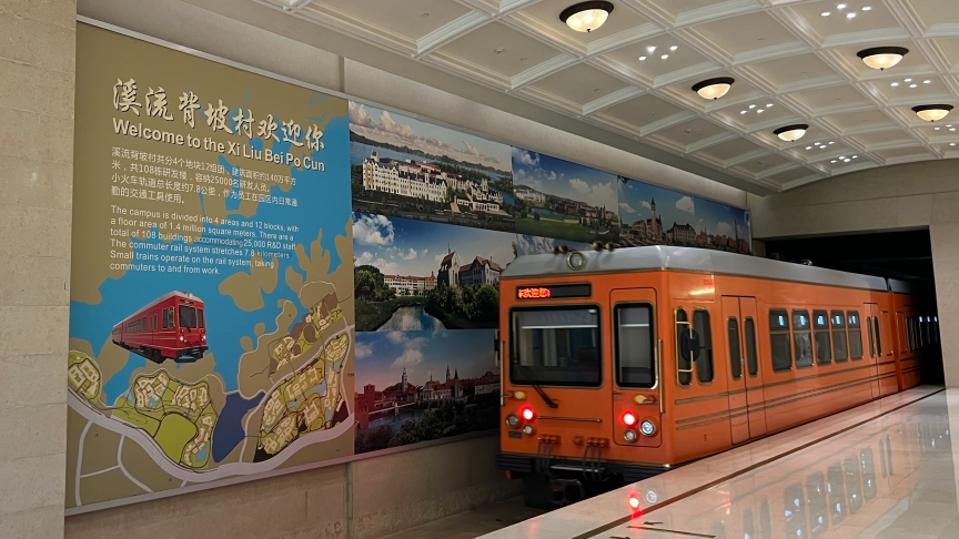 Welcome wall for Xi Liu Bei Po Cun beside a campus commuter train at Huawei Songshan Lake Campus, Dongguan