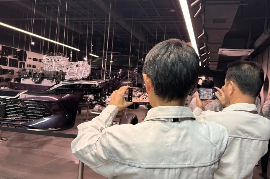 BYD electronics hall on Floor 4 of Building 7, featuring the sample wall and mask-making machine from the company's founding business