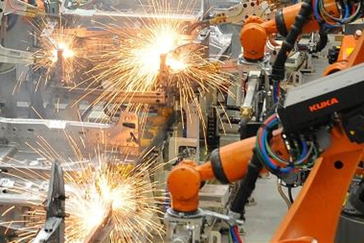 Close-up of a KUKA welding robot arm sparking on the GAC Trumpchi body-in-white line