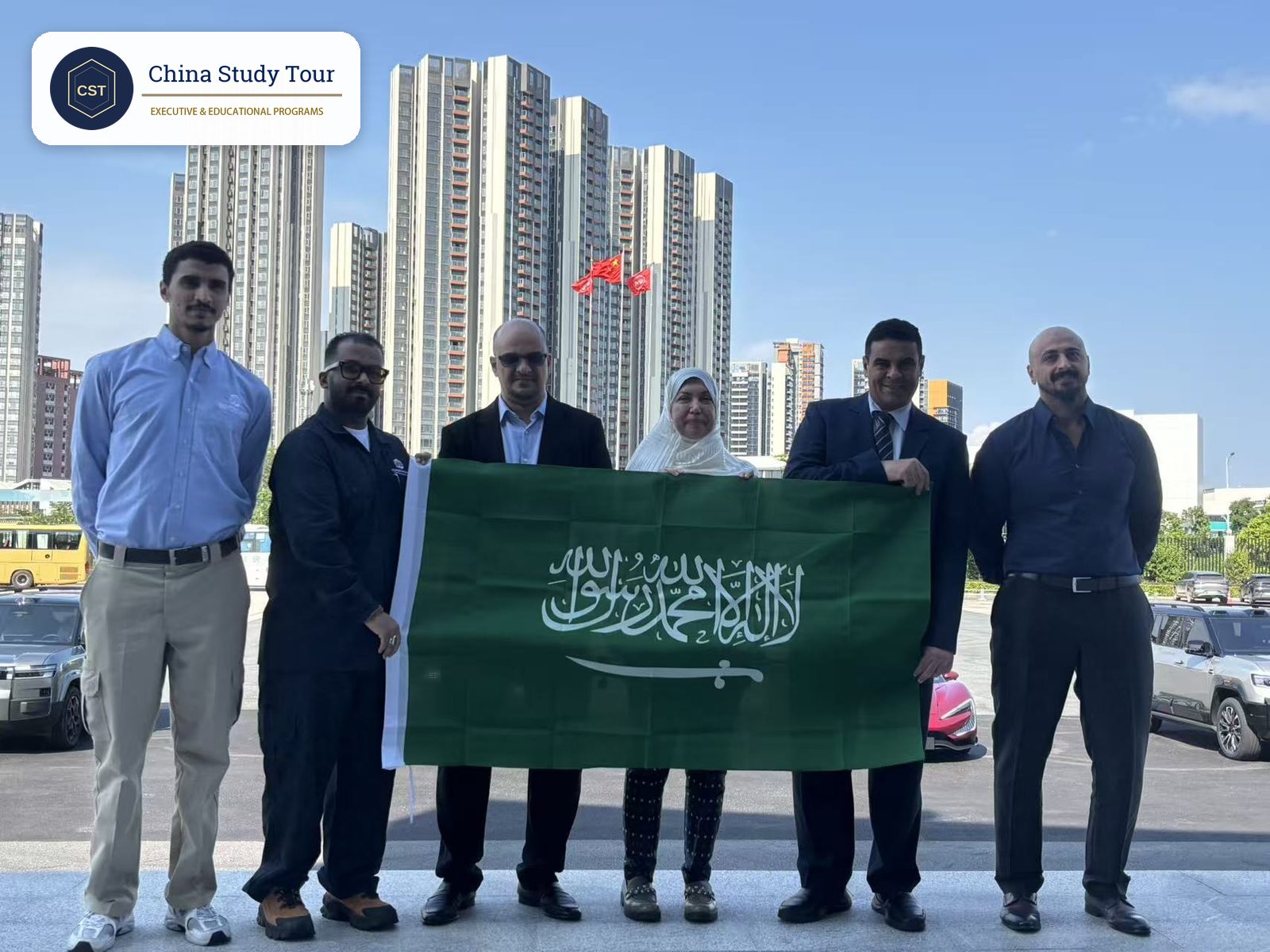 Saudi delegation holding their national flag outside the BYD headquarters in Shenzhen after the visit